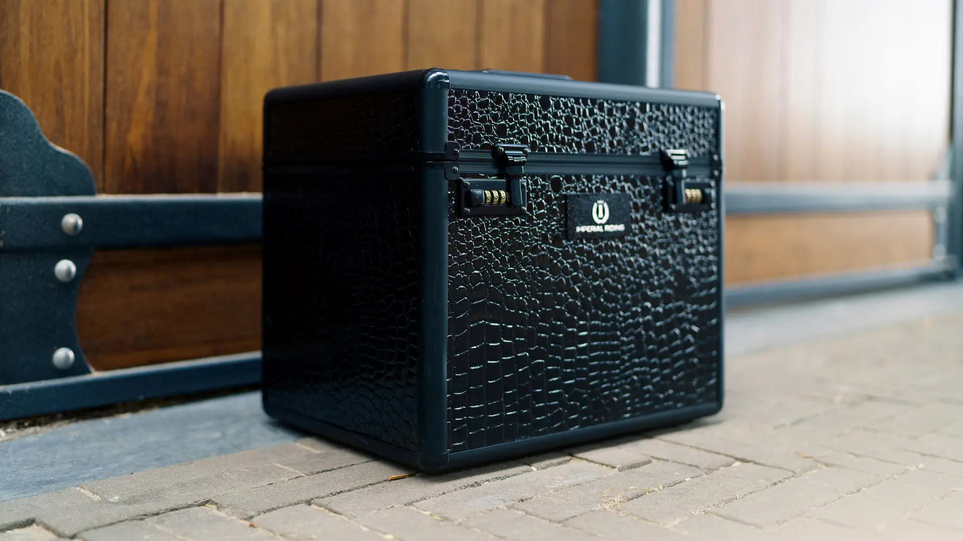 Schwarzer Putzkoffer für die Pferdepflege vor einer Stallbox