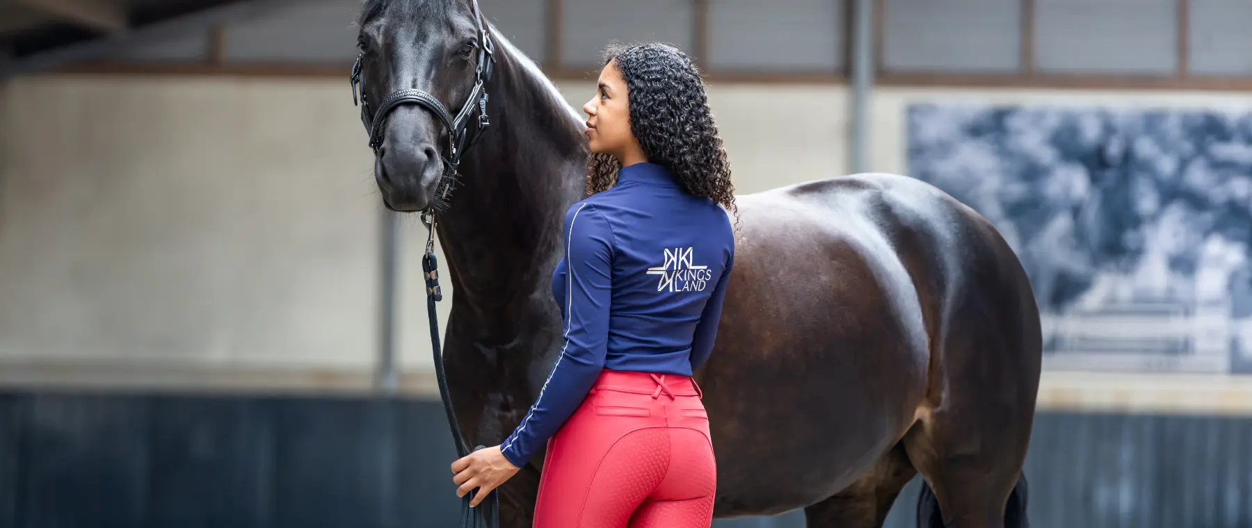 Reiterin in roter Reitleggings und marineblauer Jacke aus der Kingsland Herbst/Winter 2026 Kollektion.
