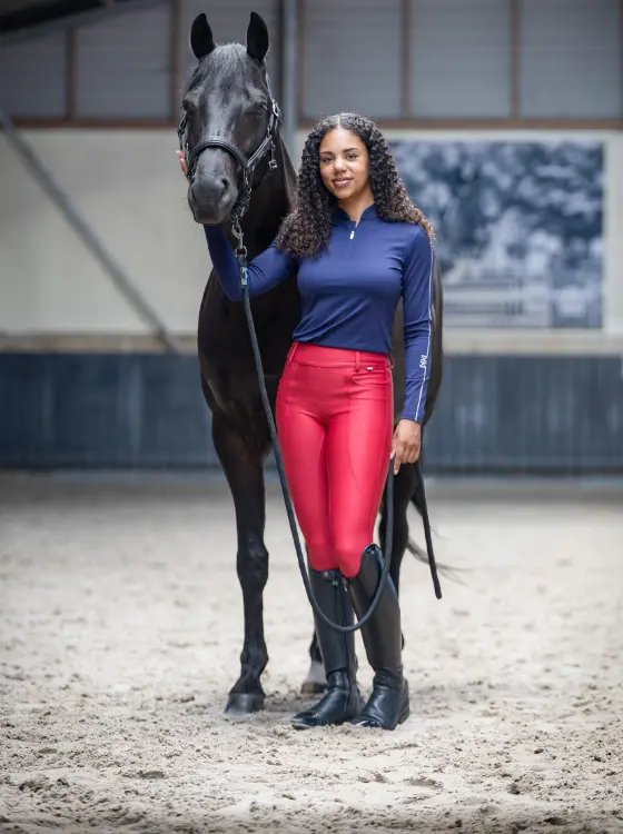 Reiterin in roter Reitleggings und marineblauer Jacke aus der Kingsland Herbst/Winter 2026 Kollektion.
